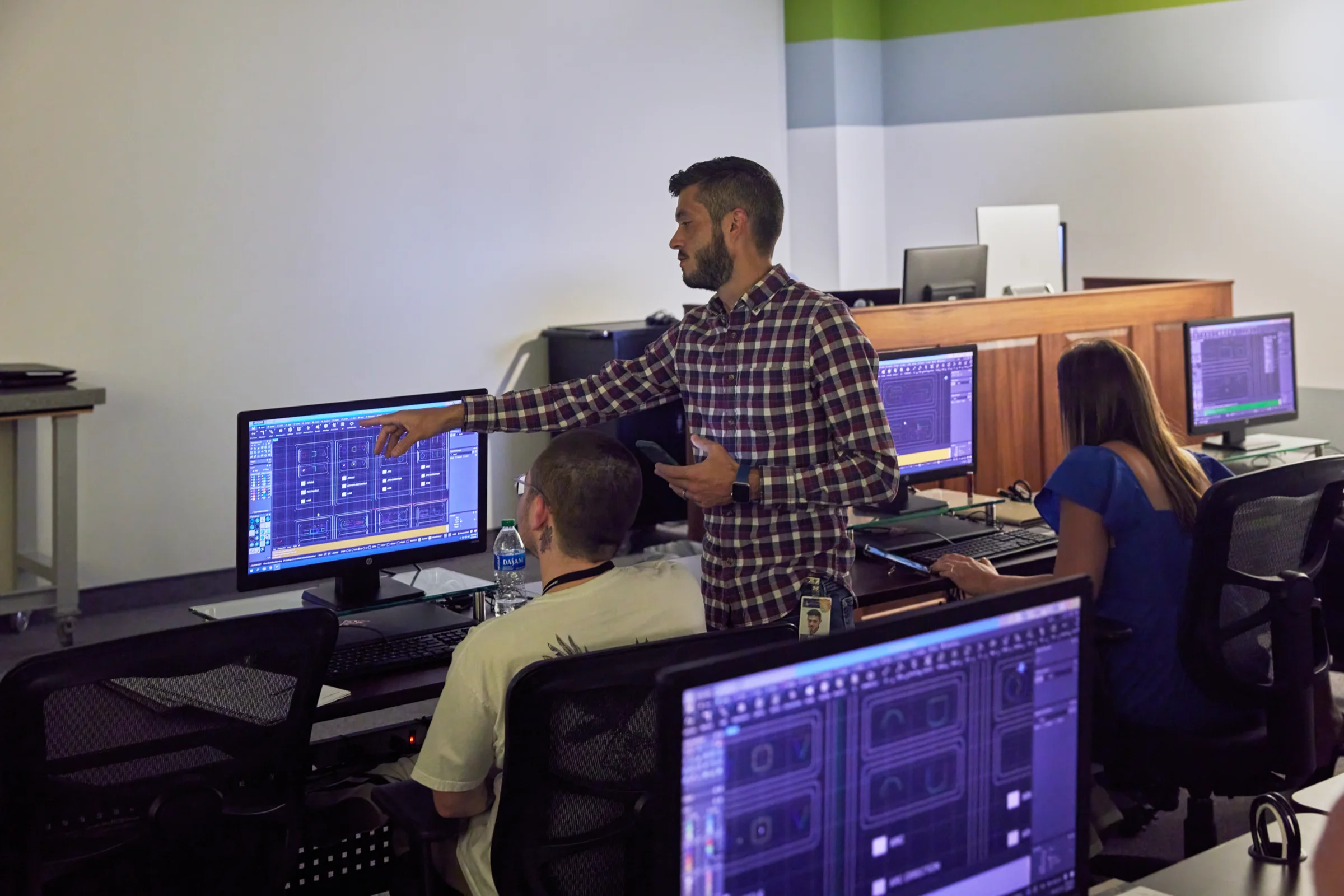 A live training session at Gemvision, an instructor points at a CAD screen beside trainees