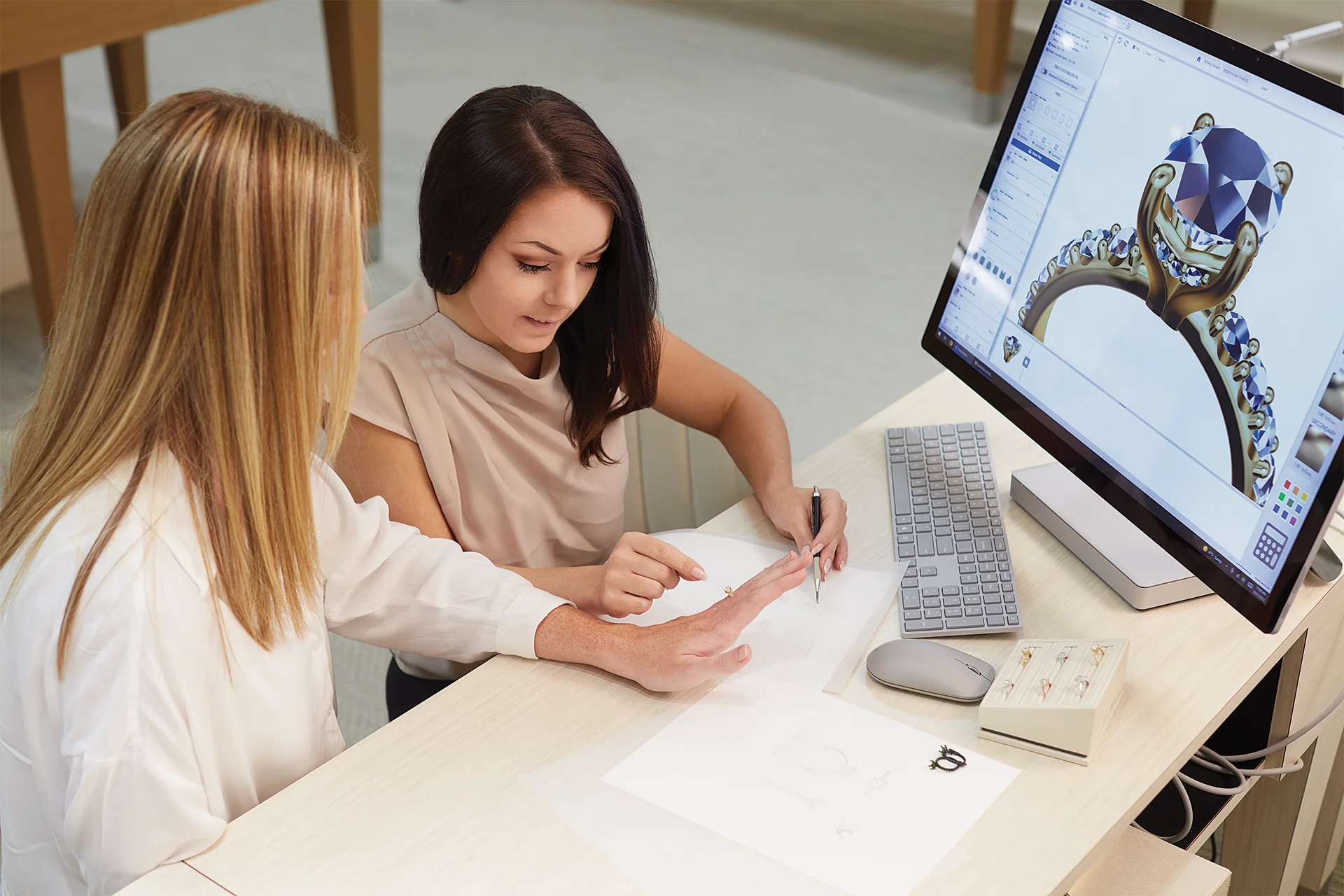 A jeweller adjusts a ring design in CounterSketch while a customer watches